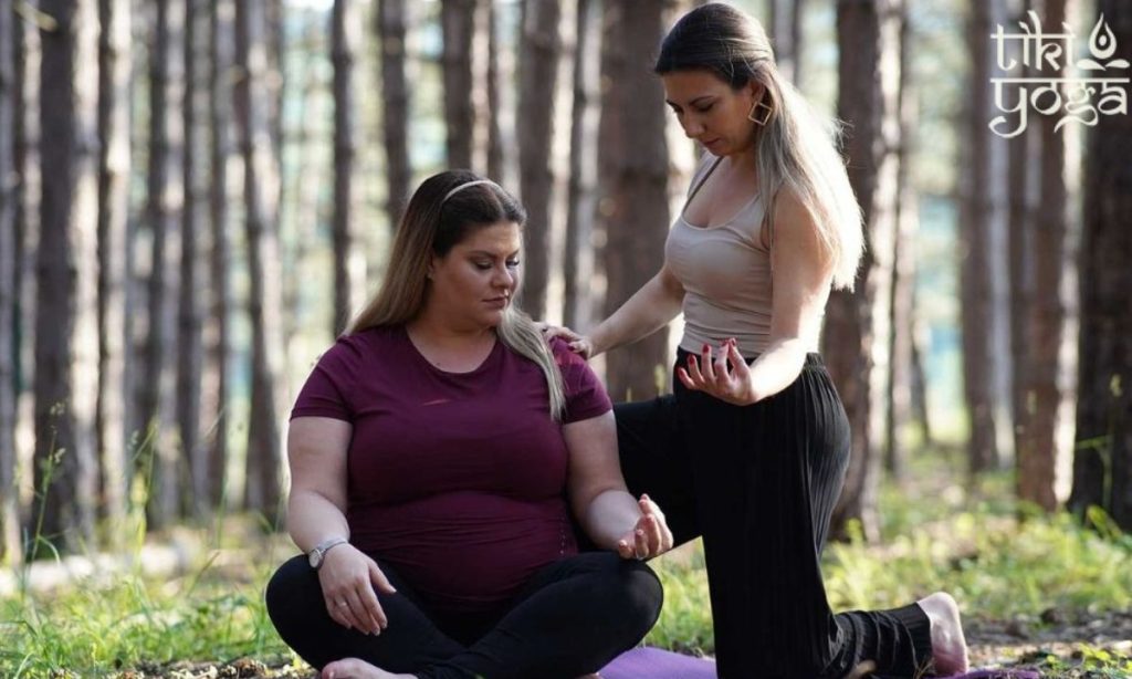 prikaz trudnice i instruktorke na času joge u prirodi